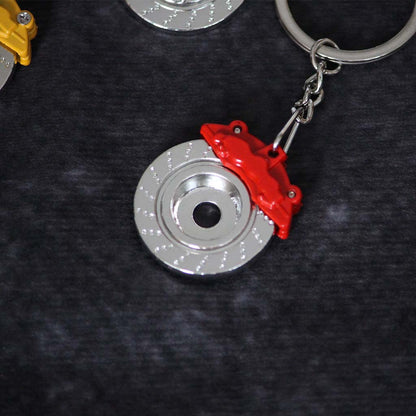 The back of a red brake disc keychain on a dark grey background