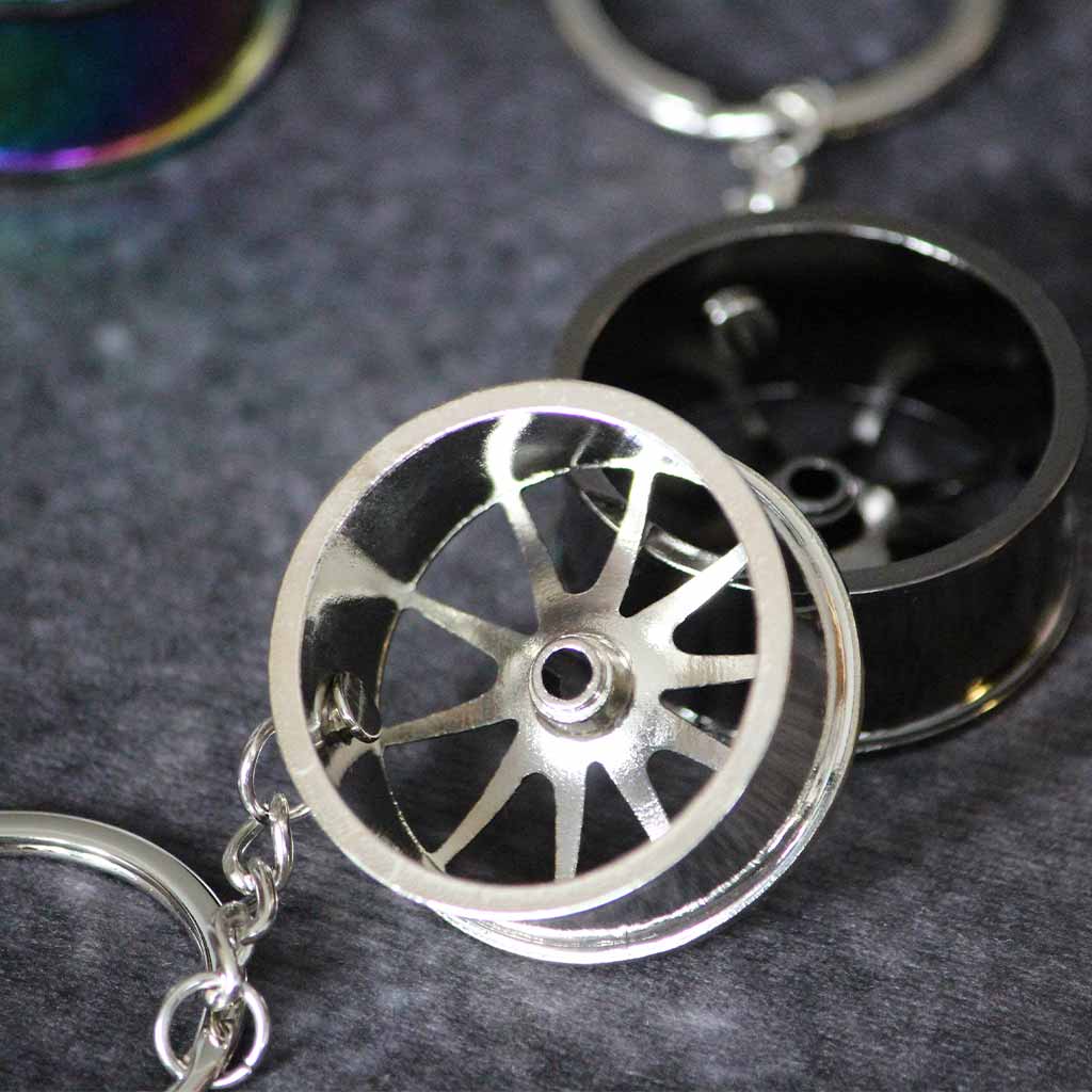 The back of a silver and a black wheel keychain