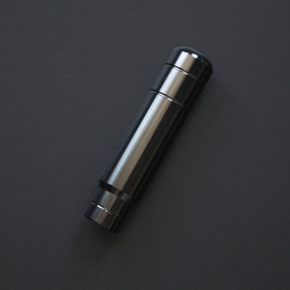 A black aftermarket shift knob flat laid on a black background