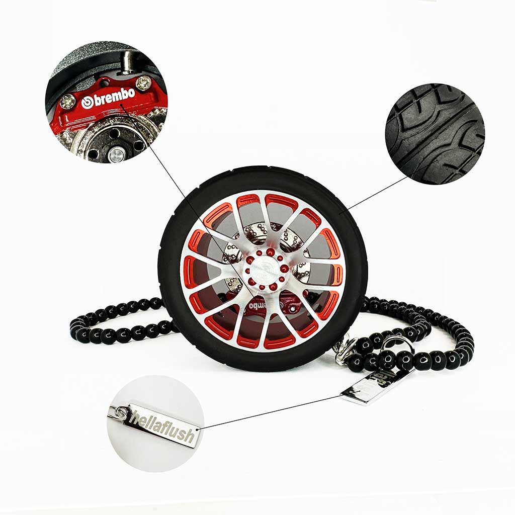 A red BBS wheel air-freshener standing on a white floor with bubbles around showcasing its details