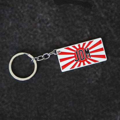 A flat lay JDM keychain on a dark grey background