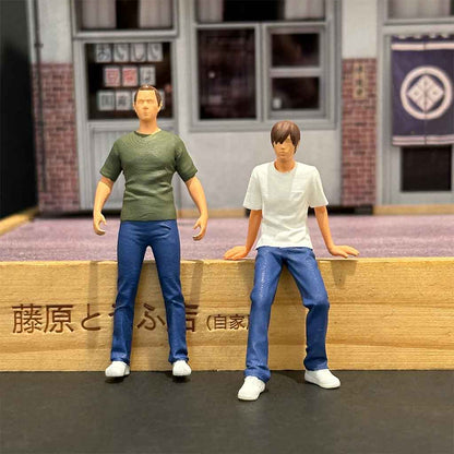 Mini figures of Fujiwara Buntai and Takumi sit on a wooden base of a Tofu Shop diorama