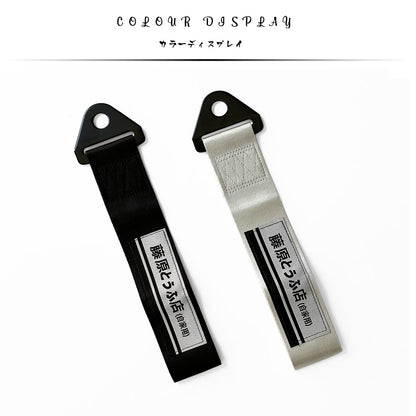 A black and a silver JDM tow strap with 'Fujiwara Tofu Shop' characters flat laid on a white background