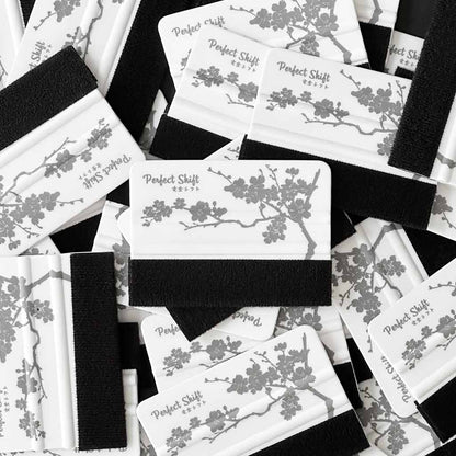 Several JDM banner sticker application squeegees with cherry blossom pattern and Perfect Shift logo on a white background