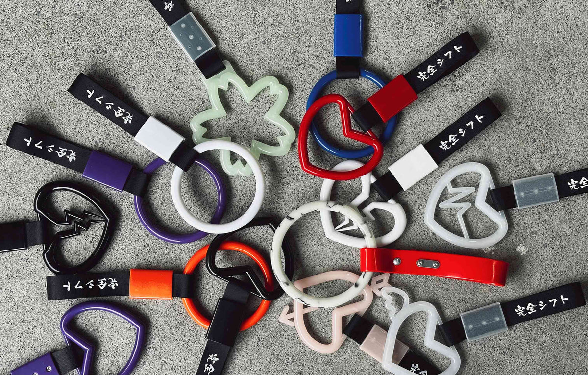A variety of JDM handle straps also known as Tsurikawas with Perfect Shift Japanese logo flat laid on a concrete ground