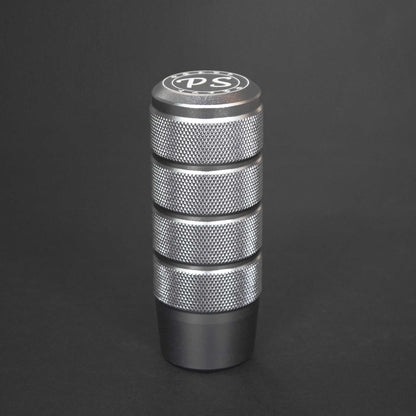 A silver shift knob standing on a black background