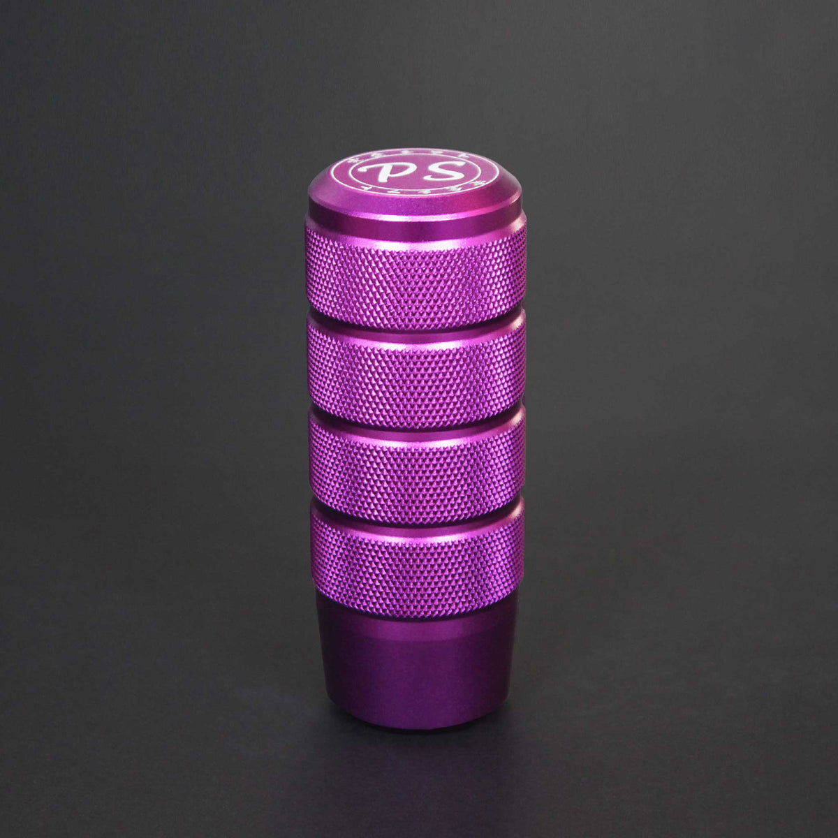 A purple shift knob standing on a black background