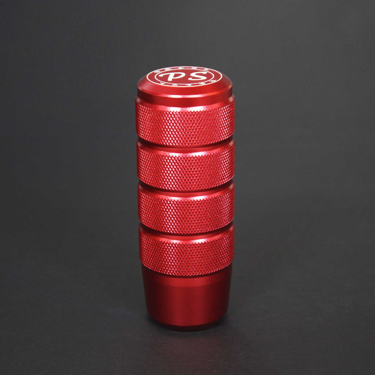 A red shift knob standing on a black background