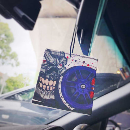 A devil JDM air freshener hung in a car