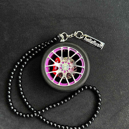 A purple BBS wheel air-freshener placed on a black background