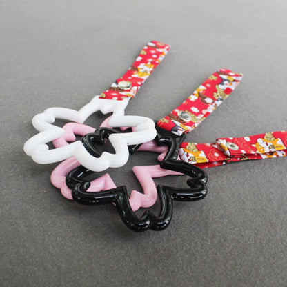 Some sakura Tsurikawas with maneki-shiba strap stacked on a concrete floor