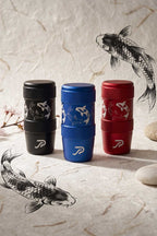 Three aluminum JDM shift knobs in black, blue, and red, each decorated with a koi fish graphic and a white Perfect Shift logo near the bottom, displayed on a textured beige surface with koi illustrations in the background.