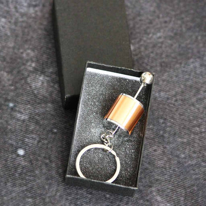  A yellow turbo keychain in a black gift box on a grey fabric as background